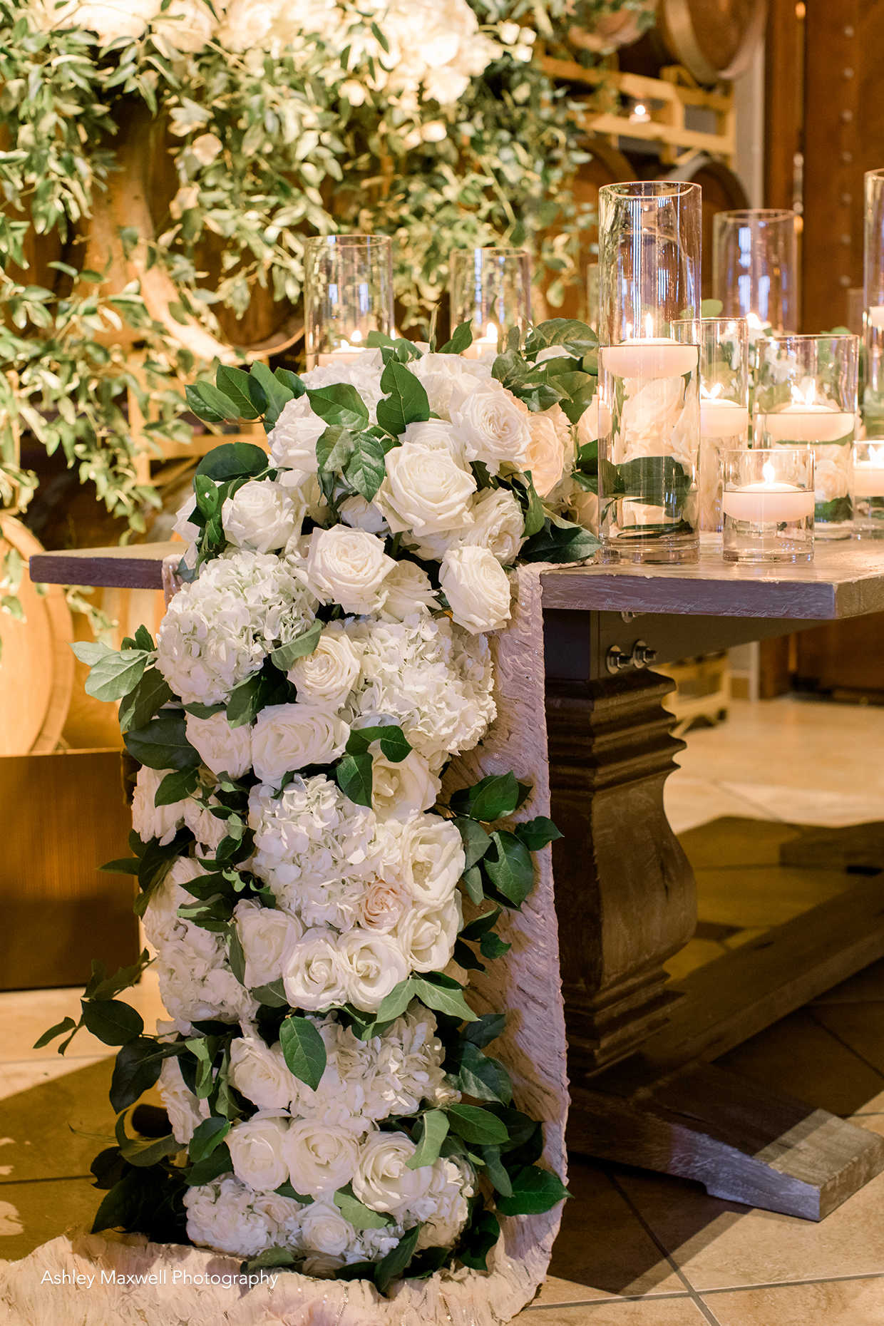 Beautiful wedding head table floral design at Casa Real at Ruby Hill Winery (www.casarealevents.com).  Photo by: Ashley Maxwell Photography; Florals: LC Floral Design; Table: Pleasanton Rentals